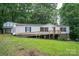 Charming home with a front porch, white siding, detached garage, and surrounded by lush greenery at 6903 Knottywood Ln # 21, Vale, NC 28168