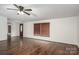 Well-lit living room featuring hardwood floors, a ceiling fan, and a view of the front door and window at 6903 Knottywood Ln # 21, Vale, NC 28168