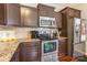 Stylish kitchen features granite countertops, stainless steel appliances, and dark wood cabinetry for a modern culinary space at 693 Carybrook Ct, York, SC 29745