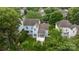 Aerial view of light blue two-story house featuring a screened in porch and surrounded by lush trees at 720 Camaross Dr, Charlotte, NC 28270