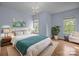 Bedroom featuring a queen bed with a white comforter, two windows, and a large potted plant at 720 Camaross Dr, Charlotte, NC 28270