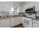 Well-lit kitchen featuring white cabinets, granite counters, and modern appliances at 720 Camaross Dr, Charlotte, NC 28270