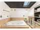 A luxurious bathroom featuring a soaking tub, natural light, and decorative cabinet at 7990 W Nc 152 Hwy, Mooresville, NC 28115