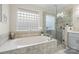 Bathroom featuring a soaking tub, glass shower, and glass block window at 800 Isle Of Palms Ct, Fort Mill, SC 29708