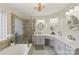 Bright bathroom featuring a soaking tub, glass shower, marble countertops, and elegant chandelier at 800 Isle Of Palms Ct, Fort Mill, SC 29708