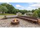 Outdoor fire pit with stone surround and wooden bench seating, ideal for gatherings and enjoying the outdoors at 800 Isle Of Palms Ct, Fort Mill, SC 29708