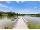 Picturesque view of a private dock extending into a serene lake under a blue sky with clouds at 8813 Covey Rise Ct, Charlotte, NC 28226