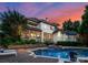 Stunning home exterior with a beautiful pool, spa, and outdoor entertaining area at sunset at 8813 Covey Rise Ct, Charlotte, NC 28226