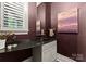 Stylish powder room with dark walls, granite countertop, and elegant mirror at 8813 Covey Rise Ct, Charlotte, NC 28226