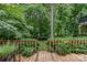 Outdoor living space with a wood deck, a gate leading to a secluded lawn surrounded by lush foliage at 8968 St Croix Ln, Charlotte, NC 28277