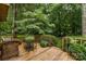 This wooden deck features a lovely green backdrop of foliage and lawn, and outdoor seating at 8968 St Croix Ln, Charlotte, NC 28277