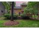 Backyard view showcasing the home's exterior, a spacious deck, and lush green lawn with mature trees at 8968 St Croix Ln, Charlotte, NC 28277