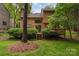 Spacious backyard featuring a two-story home with a deck surrounded by lush greenery and trees at 8968 St Croix Ln, Charlotte, NC 28277