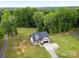 Aerial view of a home surrounded by lush greenery and mature trees in a serene setting at 943 Shinnville Rd, Mooresville, NC 28115
