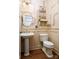 Cozy powder room with pedestal sink, decorative accents, and wainscoting, offering a charming and functional space at 943 Shinnville Rd, Mooresville, NC 28115