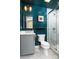 Modern bathroom with teal accent wall, framed mirror, and marble tile shower with glass door at 943 Shinnville Rd, Mooresville, NC 28115