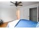 Bright bedroom with a ceiling fan, white walls, closet, and a glimpse into an adjacent room, offering spacious comfort at 943 Shinnville Rd, Mooresville, NC 28115