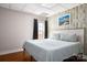 Cozy bedroom features wood floors, a queen size bed with a blue quilt, and a lighthouse picture at 943 Shinnville Rd, Mooresville, NC 28115
