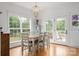 Sunlit dining room featuring a stylish chandelier and large windows showcasing outdoor views at 943 Shinnville Rd, Mooresville, NC 28115
