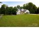 Beautiful home with a large yard, mature trees, and a charming covered front porch at 943 Shinnville Rd, Mooresville, NC 28115