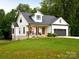 Charming white farmhouse with a cozy front porch and well-manicured lawn at 943 Shinnville Rd, Mooresville, NC 28115