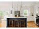 Bright kitchen with island, stainless steel appliances, white cabinets, and hardwood floors at 943 Shinnville Rd, Mooresville, NC 28115