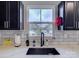 Bright kitchen area featuring stainless steel faucet, white backsplash, and a large window at 954 Taybyn Rd, Fort Mill, SC 29715
