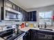 Bright kitchen area featuring stainless steel microwave, white backsplash, and plenty of counter space at 954 Taybyn Rd, Fort Mill, SC 29715