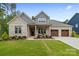 Charming brick home showcasing a manicured lawn and a welcoming three-car garage, blending style and functionality at 9833 Ardley Park Way, Mint Hill, NC 28227