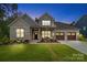 Charming brick home showcasing a manicured lawn and a welcoming three-car garage, blending style and functionality at 9833 Ardley Park Way, Mint Hill, NC 28227