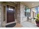 Inviting front porch with stylish bench, pillows, and lush landscaping, showcasing a cozy outdoor seating area at 9833 Ardley Park Way, Mint Hill, NC 28227
