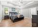 Spacious main bedroom with tray ceiling, ceiling fan, and hardwood flooring at 9833 Ardley Park Way, Mint Hill, NC 28227