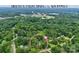 Minutes from dining and shopping! A high-angle aerial view of the home shows it is nestled in mature trees at 1010 Forest Dr, Lancaster, SC 29720