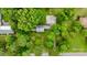 A high angle aerial view shows the home's mature trees, long driveway and large cement parking pad at 1010 Forest Dr, Lancaster, SC 29720
