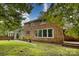 Charming backyard view showcasing the brick home and well-maintained lawn and landscaping at 1010 Forest Dr, Lancaster, SC 29720