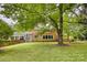 Brick home with a covered porch and generous yard under the shade of mature trees at 1010 Forest Dr, Lancaster, SC 29720