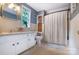 Traditional bathroom featuring neutral tile, a window and a white vanity and storage at 1010 Forest Dr, Lancaster, SC 29720
