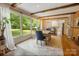 Sun-filled dining area with large windows overlooking the lush backyard and features a charming brick fireplace at 1010 Forest Dr, Lancaster, SC 29720