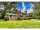 A two-story brick home on a well-manicured lawn under a blue sky on a sunny day at 1010 Forest Dr, Lancaster, SC 29720