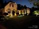 Charming home with exterior lighting highlighting the architectural details at night at 1032 Seminole Dr, Waxhaw, NC 28173