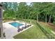 Stunning backyard with a large pool, hot tub, lounge chairs, and a private wooded view at 1032 Seminole Dr, Waxhaw, NC 28173