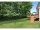 Well-maintained backyard with mature trees, a spacious lawn, and a wooden deck at 11103 Fountaingrove Dr, Charlotte, NC 28262