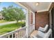 Relaxing front porch view with white columns, railings, wicker chairs, and a view of the front yard at 11103 Fountaingrove Dr, Charlotte, NC 28262