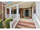 Inviting front porch with brick steps, white railings, and a black front door with sidelights at 11103 Fountaingrove Dr, Charlotte, NC 28262