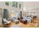 Spacious living room with tall windows, wood floors, neutral walls and opening to the kitchen at 11103 Fountaingrove Dr, Charlotte, NC 28262