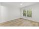 Neutral bedroom with natural light, wood-look flooring, and minimalist style at 1123 Market St, Fort Mill, SC 29708