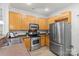 Well-lit kitchen with stainless steel appliances, wooden cabinets, and modern flooring at 1123 Market St, Fort Mill, SC 29708