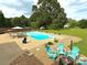 Relaxing backyard with a pool, patio dining set, and inviting seating area with a fire pit at 141 Weathers Creek Rd, Troutman, NC 28166
