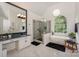 Elegant bathroom featuring a soaking tub, glass-enclosed shower, and marble flooring at 14831 Charterhouse Ln, Huntersville, NC 28078