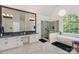 Luxury bathroom featuring a soaking tub, glass-enclosed shower, and marble flooring at 14831 Charterhouse Ln, Huntersville, NC 28078